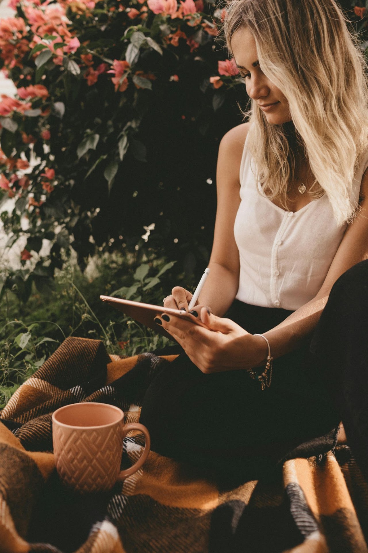 Woman writing outdoors with a notebook